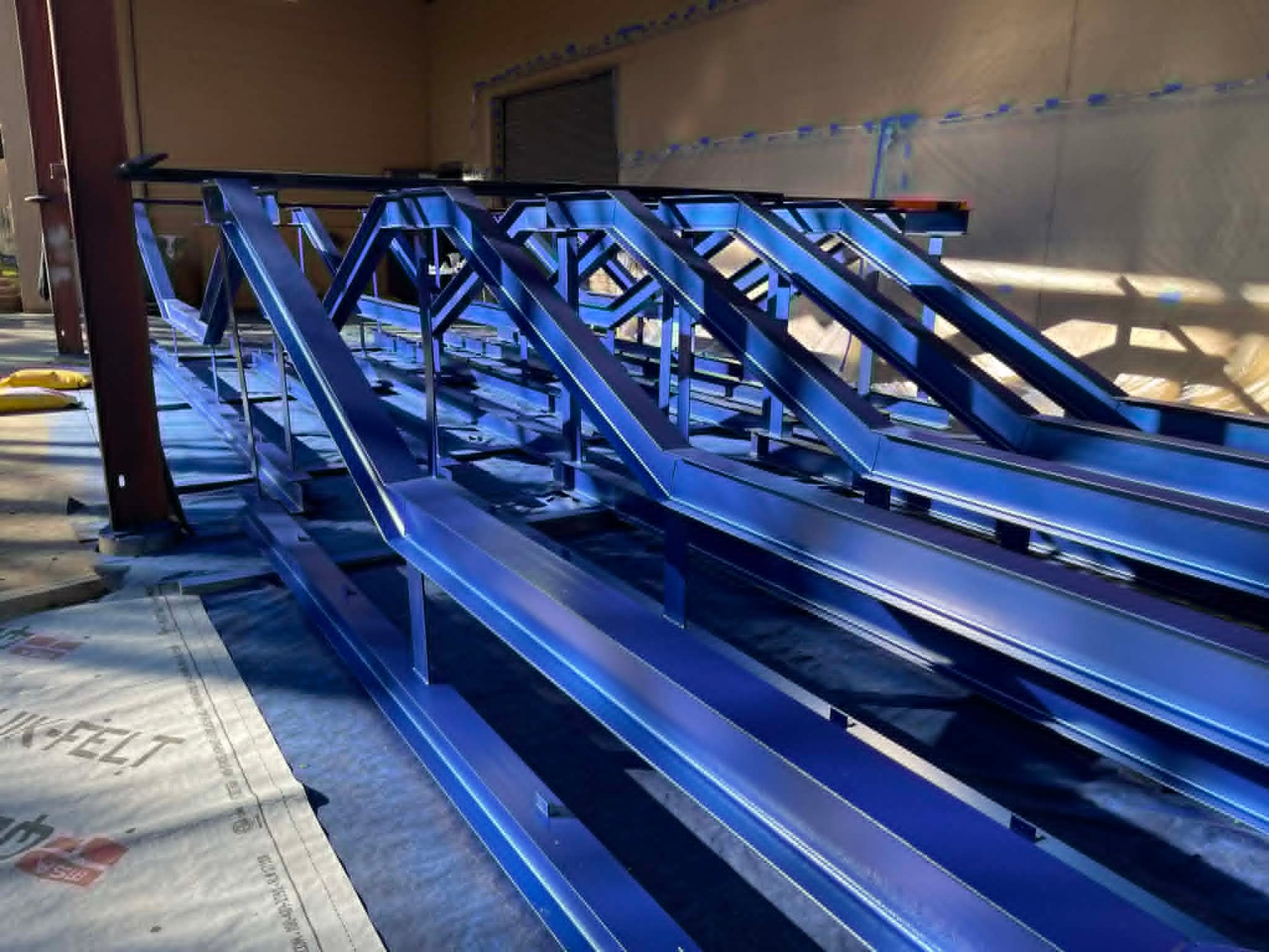 Carlson Painting Co. industrial exterior services featuring high-durability blue protective coatings applied to structural steel trusses. Carlson Painting Co. industrial exterior services featuring high-durability blue protective coatings applied to structural steel trusses.