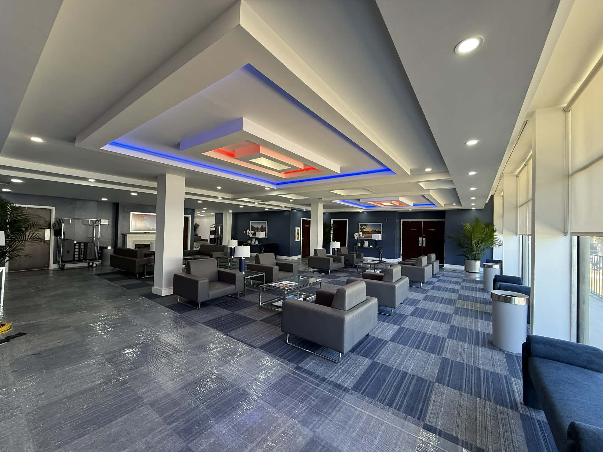 Luxury interior painting in Atlanta showcasing a navy blue accent wall and layered tray ceiling.