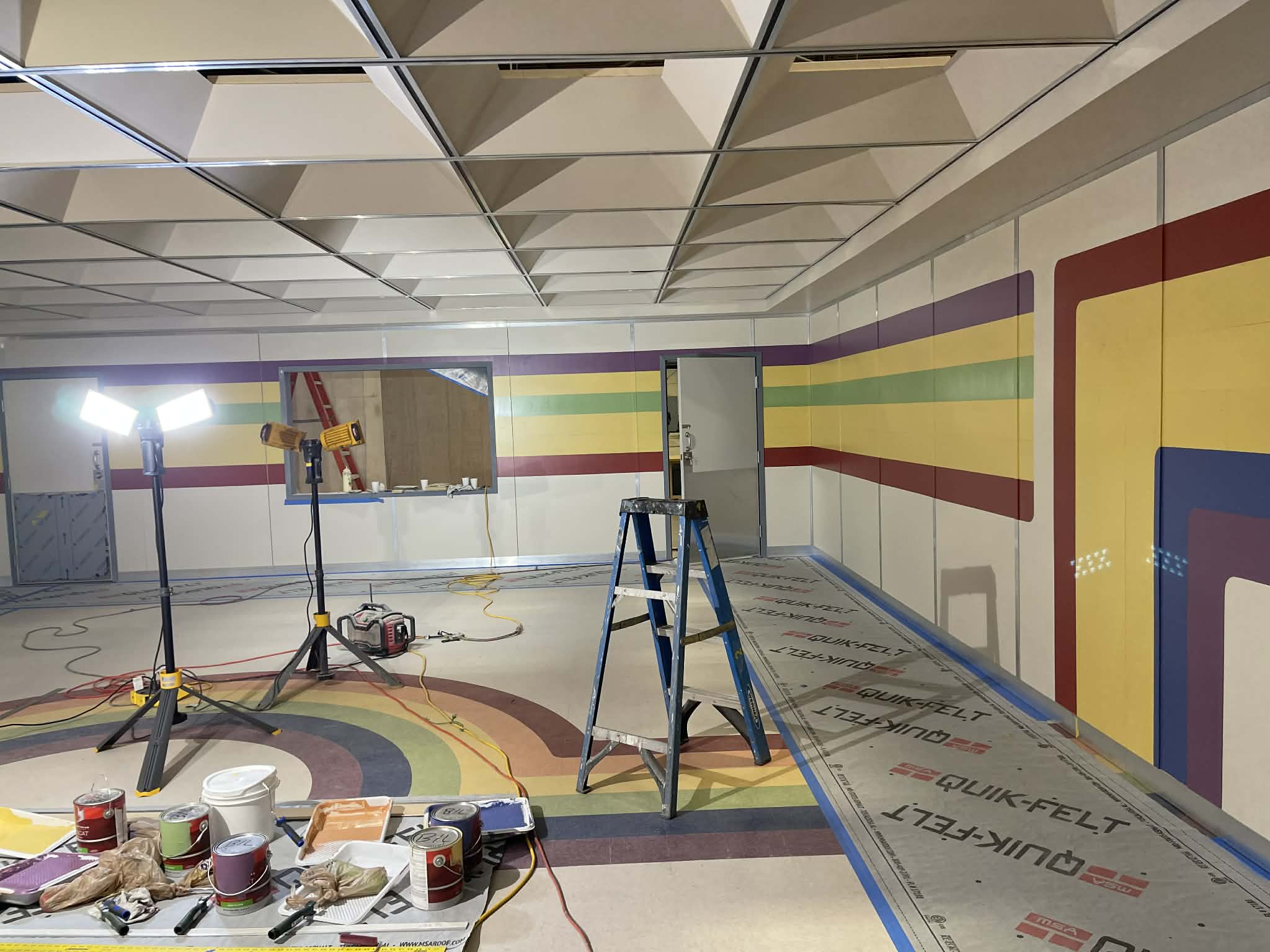 Professional interior painting preparation in Atlanta featuring full floor protection and staging lights.